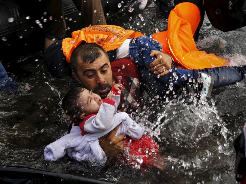 Refugiado sírio segura seu filho, durante travessia em um bote, na ilha grega de Lesbos. Foto vencedora do prêmio Pulitzer, o maior do fotojornalismo mundial - 24/09/2015