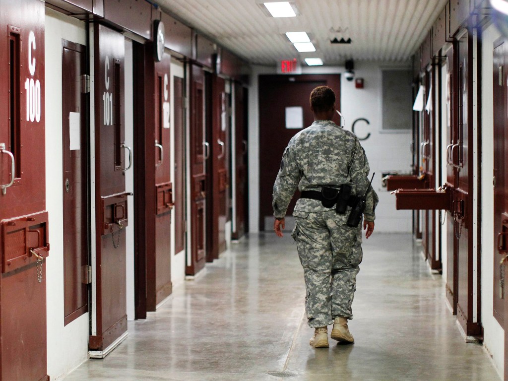 Guarda caminha através de um bloco de celas na prisão da base naval dos Estados Unidos na Baía de Guantánamo, em Cuba
