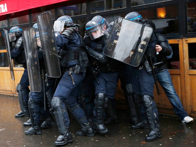 Policiais franceses se protegem com escudos, durante protesto contra as reformas na legislação trabalhista, na capital Paris, nesta quinta-feira (31)