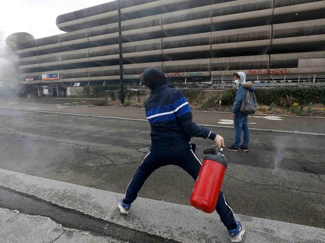 Manifestante lança extintor de incêndio contra policiais, durante protesto contra as reformas na legislação trabalhista, na cidade de Nantes, na França, nesta quinta-feira (31)