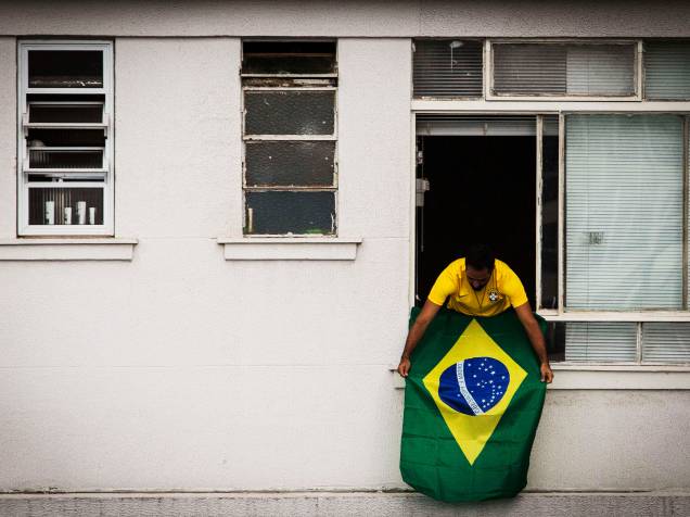 Homem acompanha protesto contra o governo Dilma e a corrupção na Petrobras, na janela de seu apartamento na avenida Paulista, em São Paulo - 15/03/2015