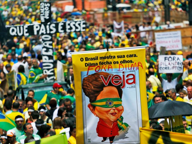 Manifestantes erguem faixas, cartazes e bandeiras durante protesto contra o governo Dilma na Avenida Paulista, região central de São Paulo, neste domingo (15)