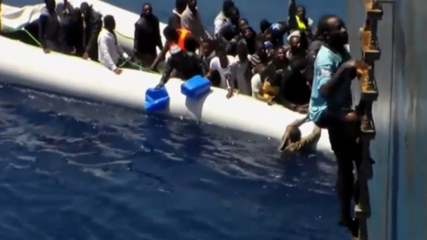 Imigrantes lutam para subir a bordo de navio cargueiro no Mediterrâneo