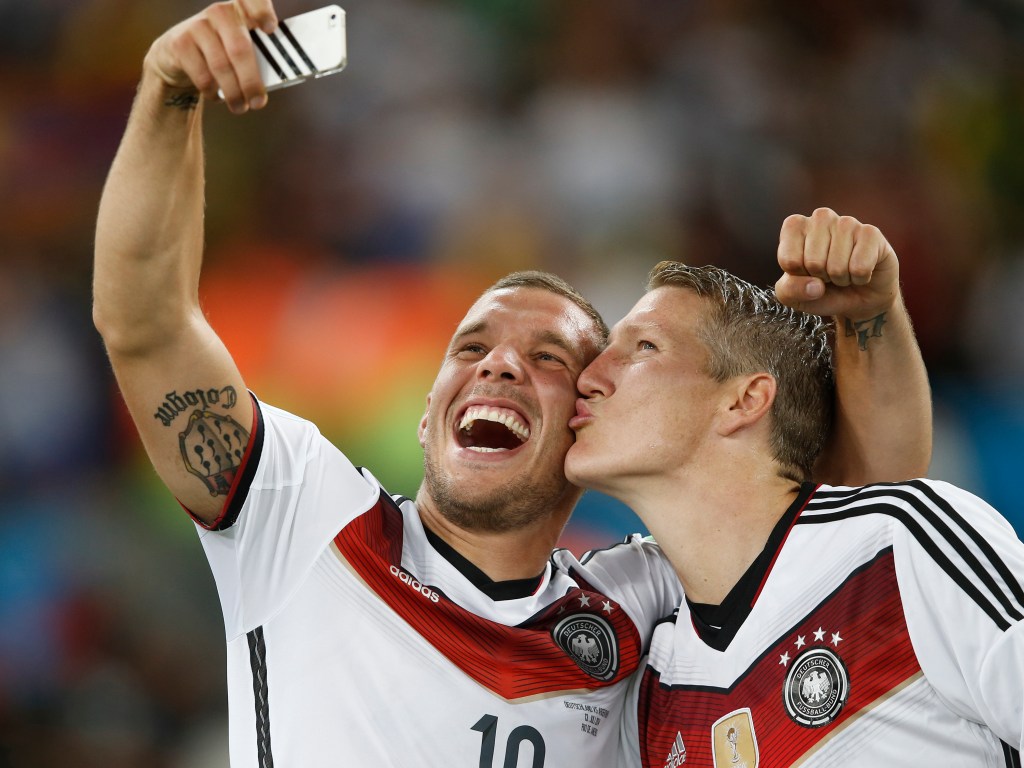 Os jogadores Bastian Schweinsteiger e Lukas Podolski tiram 'selfie' após a Alemanha vencer a Copa do Mundo realizada no Brasil