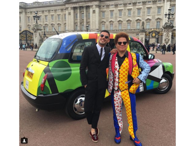 Artista plástico Romero Britto posa com terno estampado da marca Dolce & Gabbana em frente ao Palácio de Buckingham, em Londres