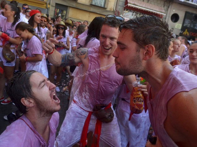 Foliões cospem vinho um no outro durante as celebrações do Chupinazo, que marca o início da Festa de São Firmino em Pamplona, Espanha