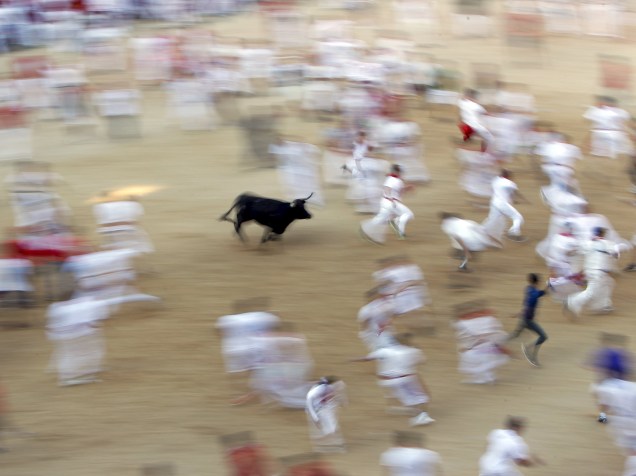 Touro corre atrás da multidão durante a terceira corrida dos touros no Festival de São Firmino, em Pamplona, Espanha. Seis corredores foram hospitalizados após a corrida que durou apenas dois minutos e vinte e sete segundos