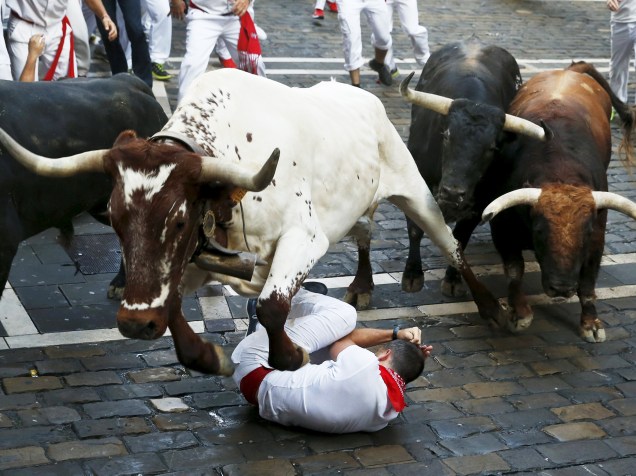 Touro pula sobre um corredor caído durante a a corrida dos touros, parte das celebrações do Festival de São Firmino, em Pamplona, Espanha