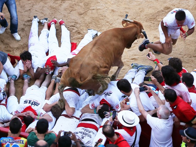 Um touro pula por cima de participantes durante o primeiro "encierro", a famosa corrida de touros do Festival de São Firmino, em Pamplona, Espanha