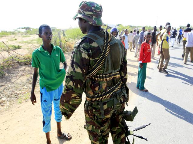 Soldado da Força de Defesa do Quênia tenta afastar as crianças da universidade atacada pelo grupo islâmico al Shabbab, em Garissa - 02/04/2015