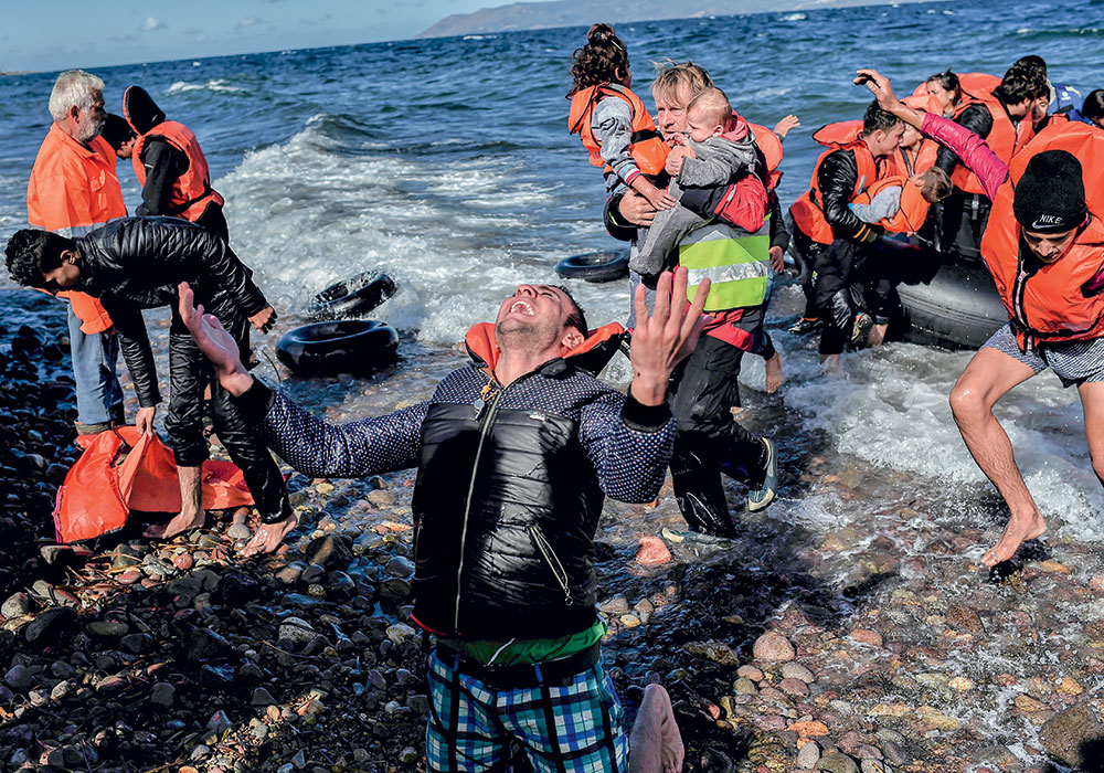 ALÍVIO -  Um refugiado comemora ao desembarcar na Ilha de Lesbos, na Grécia. Para ele, o pior ficou para trás