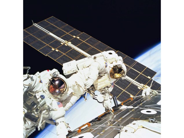 <p>Os astronautas Jerry L. Ross e James H. Newman trabalham juntos nas últimas três caminhadas espaciais da missão STS-88</p>