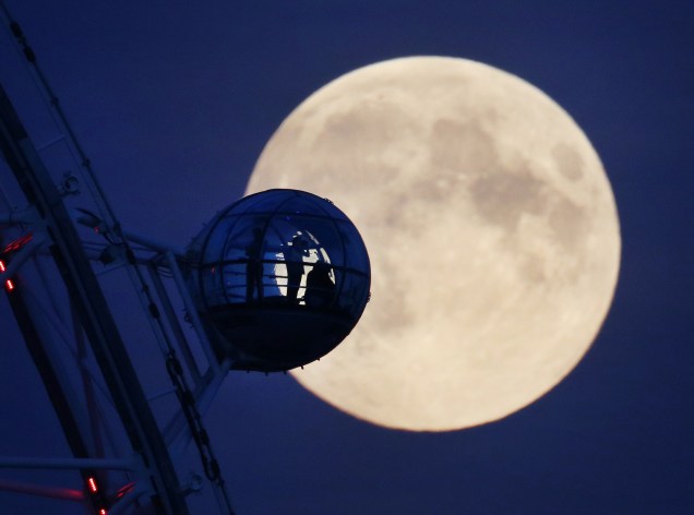 Visitantes da roda-gigante London Eye observam a lua cheia perto de Whitehall, em Londres