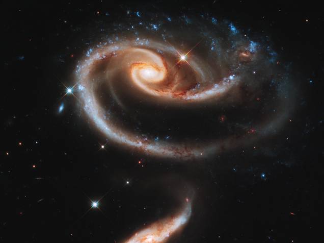 <p>Duas galáxias interagindo gravitacionalmente formando uma rosa celestial</p>