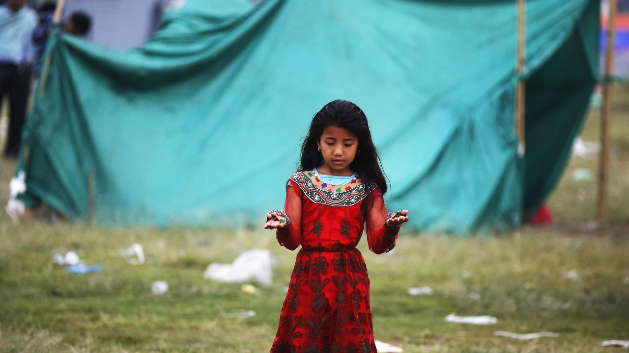 Criança reza em homenagem às vítimas do terremoto que devastou o Nepal