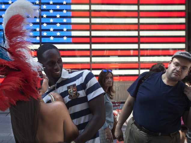 Homem olha mulher que posa com pintura corporal na Times Square. O prefeito de Nova York pensa em medidas para acabar com a atividade