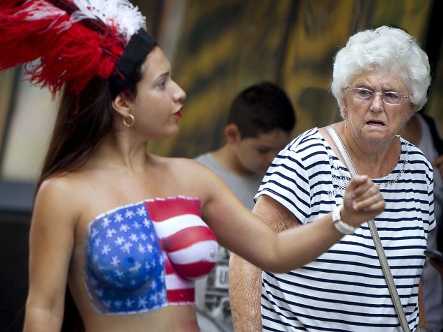 Mulheres fazendo topless posam com turistas em troca de gorjetas na Times Square, Nova York