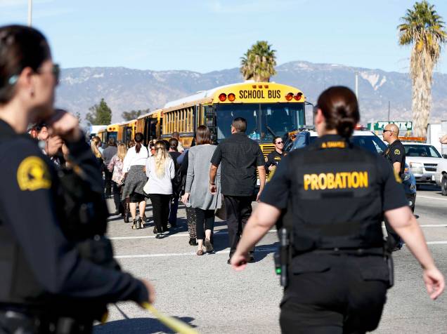 Policiais transportam espectadores da área onde ocorreu um tiroteio em San Bernardino, Califórnia