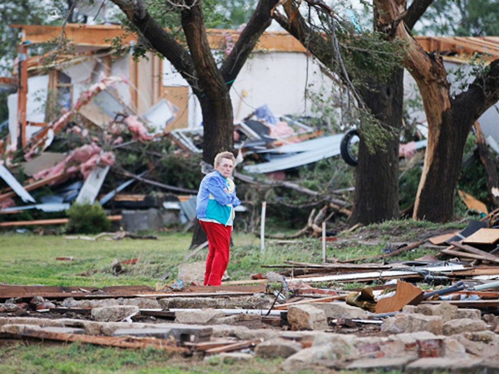 Mulher observa a destruição por tornado em sua fazenda perto de Bentley, no Kansas (EUA)
