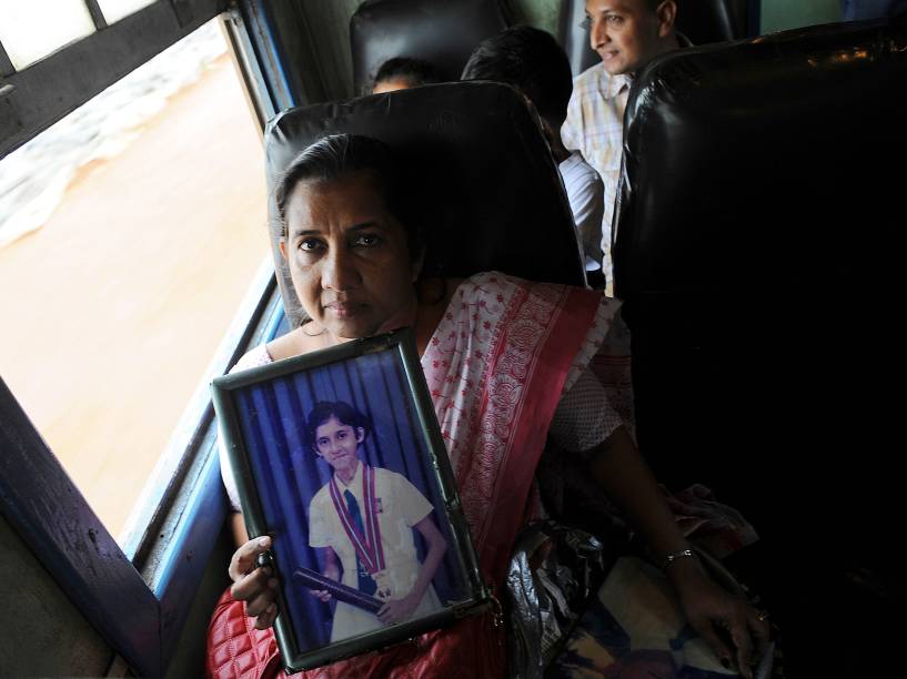 Shanthi Gallage, sobrevivente do tsunami que atingiu o Sri Lanka, segura uma foto de sua filha Inosha, morta na ocasião, durante viagem no trem de Colombo para Peraliya