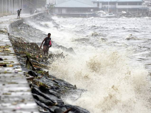 Residentes procuram por pertences entre ondas causadas pelo tufão Koppu em Manila