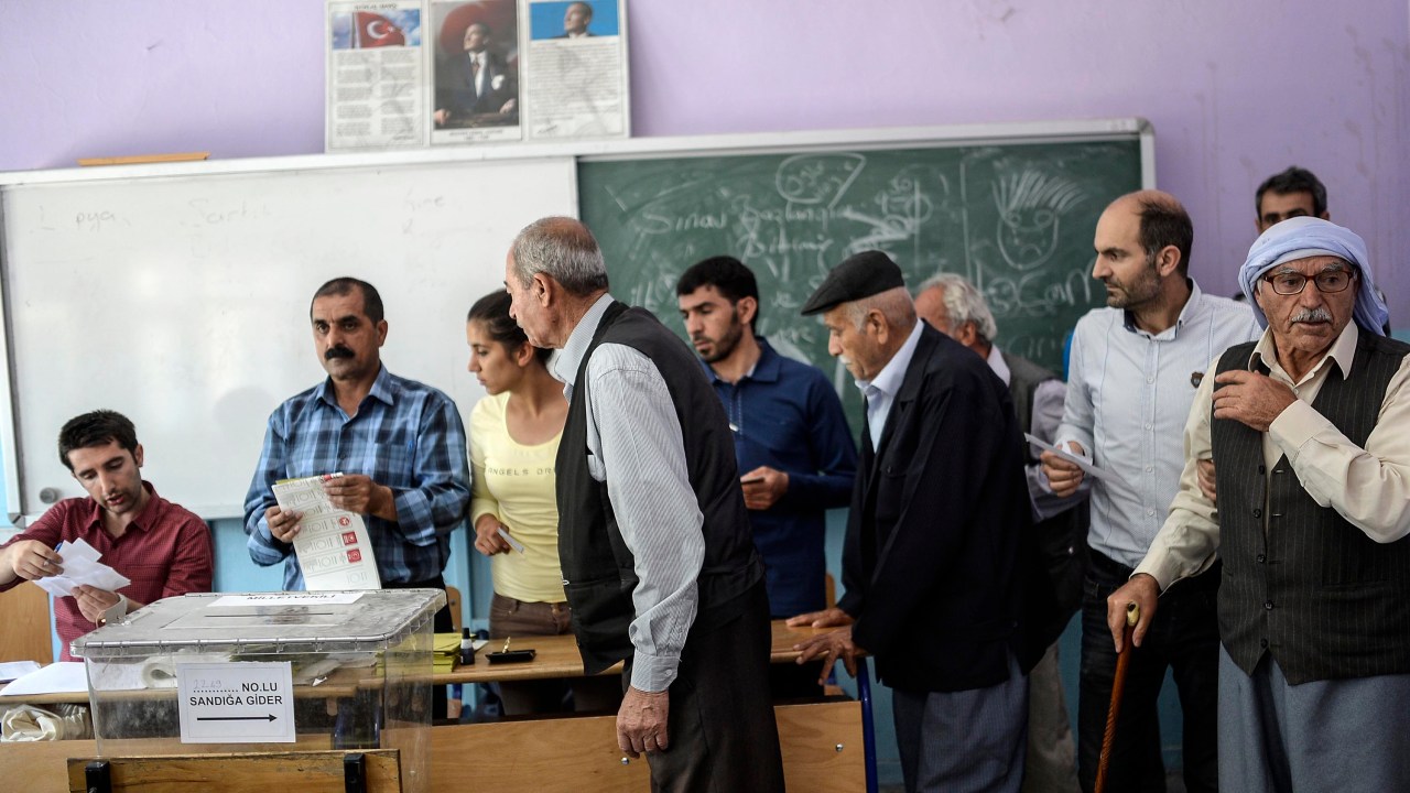 Homens turcos aguardam para votar em Istambul na manhã deste domingo (7), dia da eleição geral no país
