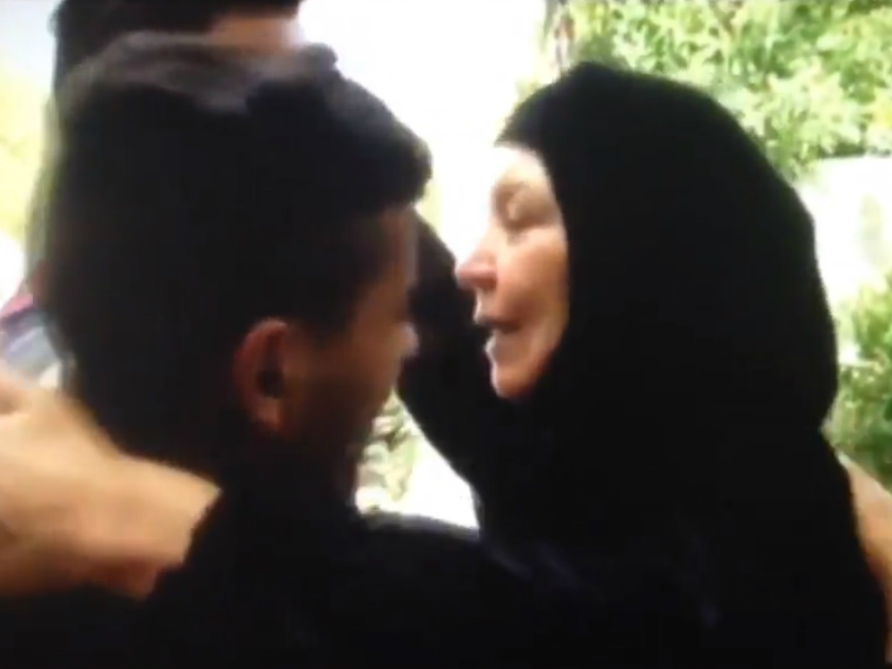 Um Qusai, a 'mãe dos iraquianos', abraça dois soldados que ela salvou da morte
