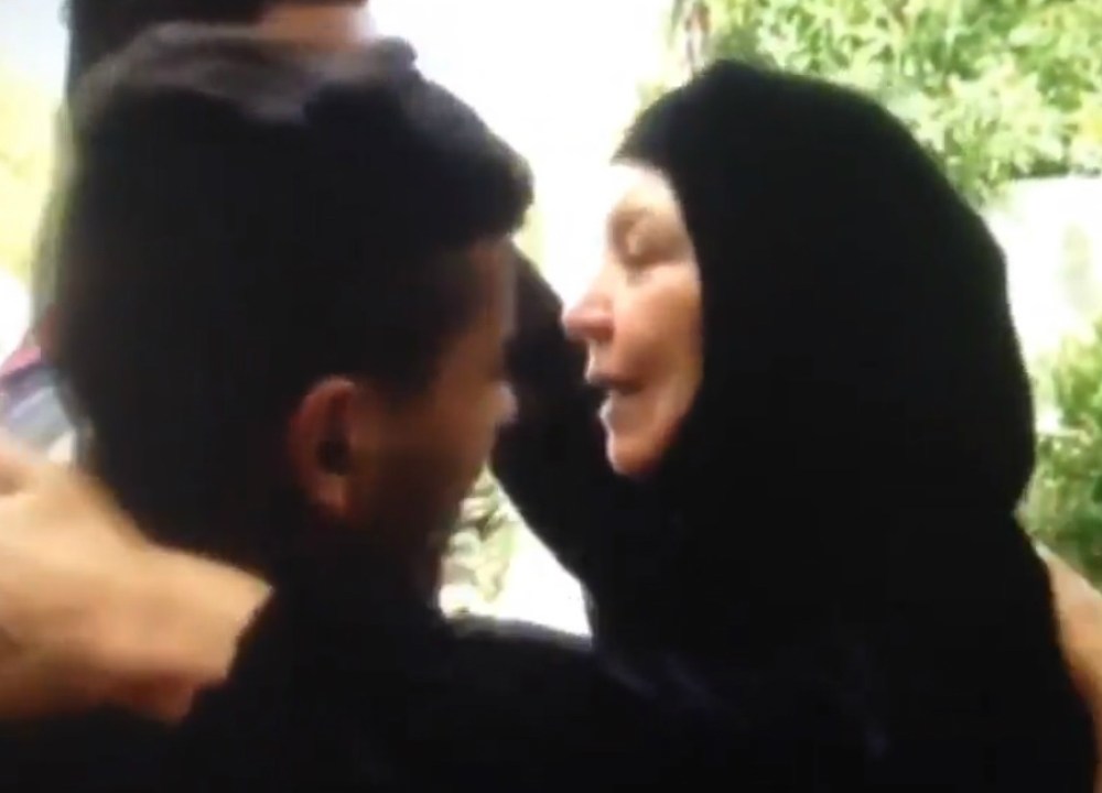 Um Qusai, a 'mãe dos iraquianos', abraça dois soldados que ela salvou da morte
