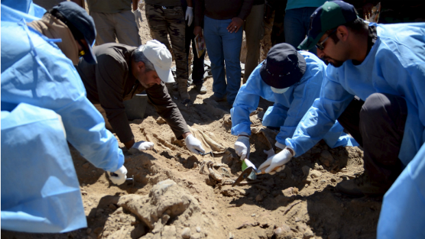 Membros da equipe forense iraquiana trabalham na extração dos corpos das valas comuns encontradas em Tikrit