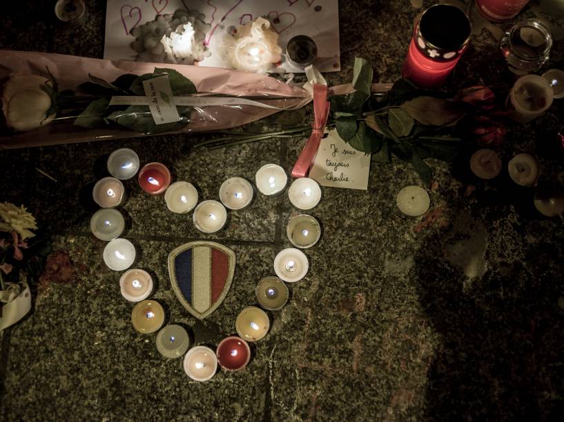 Pessoas acendem velas em homenagens às vítimas dos atentados aos restaurantes Le Petit Cambodge e o Le Carillon em Paris