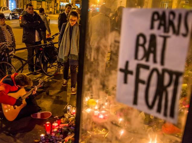 Pessoas acendem velas em homenagens às vítimas dos atentados aos restaurantes Le Petit Cambodge e o Le Carillon em Paris