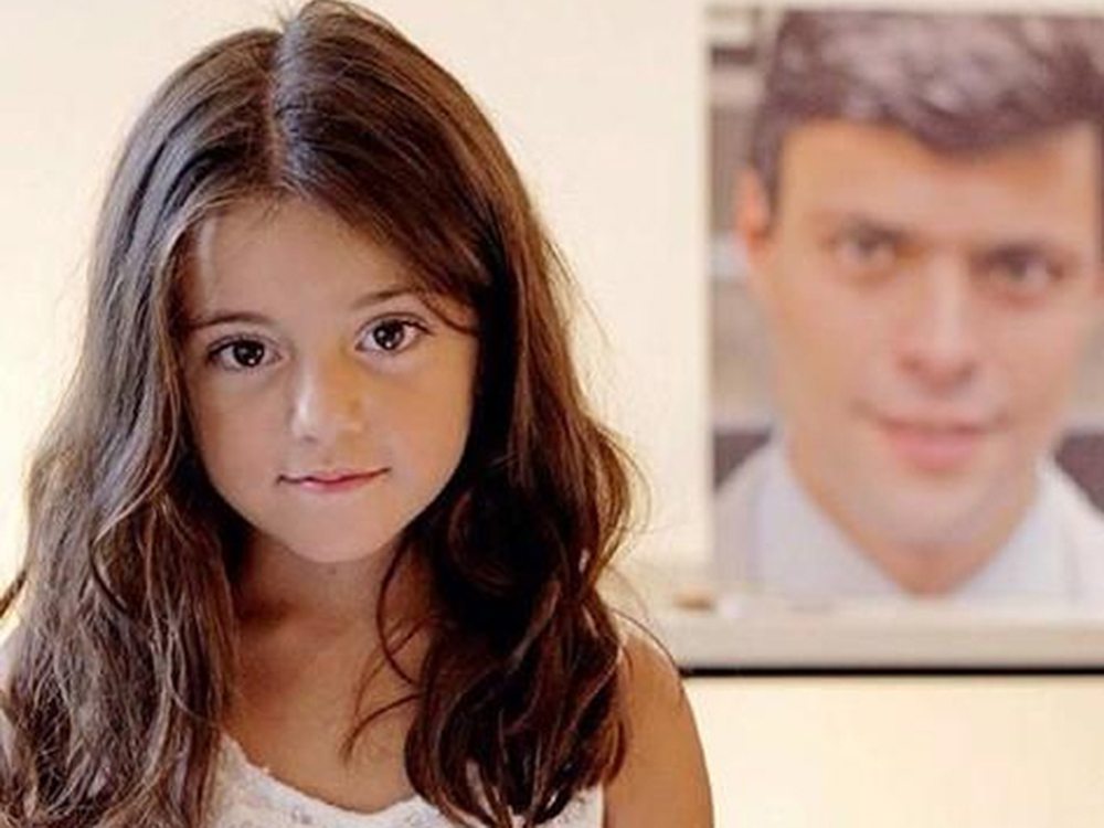Manuela López aparece ao lado da fotografia de seu pai o líder oposicionista venezuelano, Leopoldo López