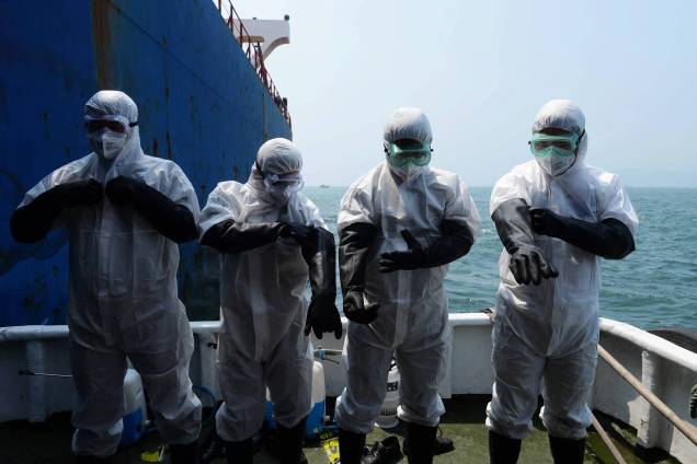Na China, funcionários de um navio de carga passam por procedimento contra o contágio do vírus Ebola, em 19/08/2014