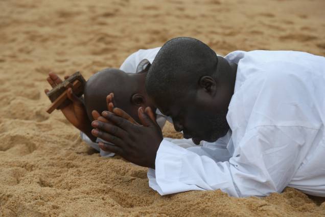Fiéis são fotografados rezando na praia de Aladura, na província de Monróvia, na Libéria. O país passa por uma crise humanitária desde que o vírus Ebola se expalhou em todo o território nacional