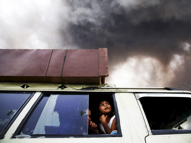 <p>Família deixa área de zona de perigo durante uma erupção do vulcão do Monte Sinabung em Karo Regency, no norte de Sumatra, na Indonésia</p>