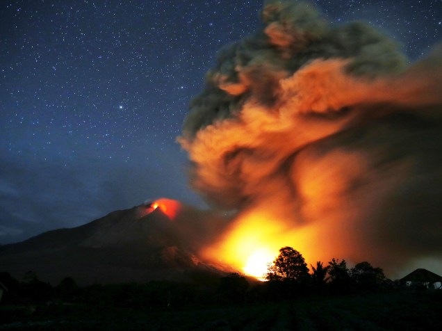 <p>Monte Sinabung expele lava em foto tirada a partir de uma aldeia vazia em Karo, província de Sumatra do Norte, na Indonésia - 25/06/2015</p>
