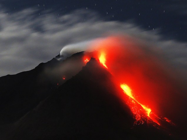 <p>Monte Sinabung expele lava em foto tirada a partir de uma aldeia vazia em Karo, província de Sumatra do Norte, na Indonésia - 25/06/2015</p>