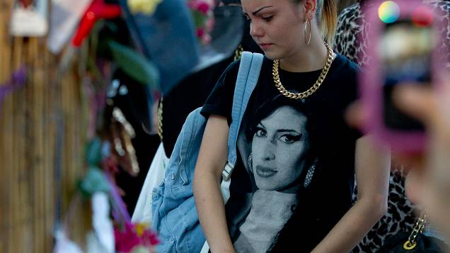 Admiradora da cantora britânica Amy Winehouse se reúne em frente a casa onde ela morreu, em Londres, no aniversário de um ano de sua morte