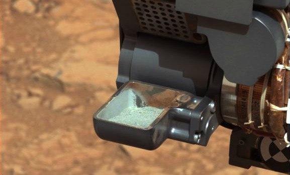 Imagem do robô Curiosity mostra a primeira amostra de pó de rocha retirado de solo de Marte
