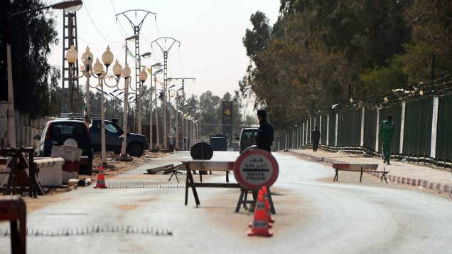Policiais argelinos param carros em posto de controle em Amenas, perto da fronteira com a Líbia