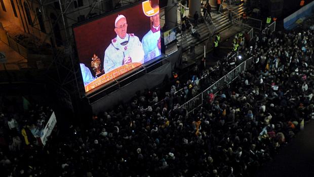 Católicos acompanham por um telão instalado em frente à catedral de Buenos Aires, Argentina, a missa de início do pontificado do papa Francisco