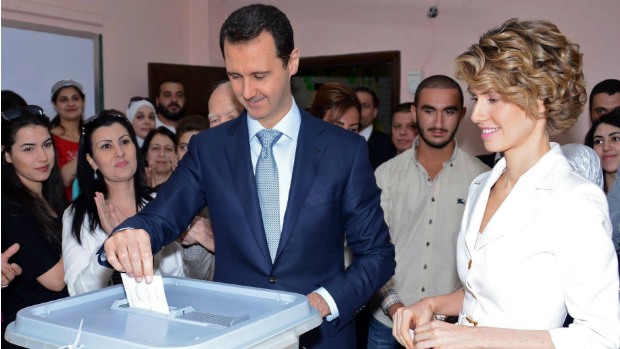 O ditador Bashar Assad, acompanhado de sua mulher Asmaa, vota em Damasco