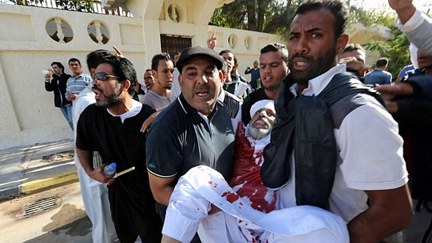 Homem ferido é carregado após tiroteio na Líbia