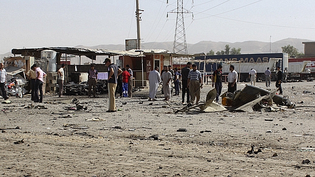 Moradores de Tuk, no Iraque, observam área que foi alvo de atentado