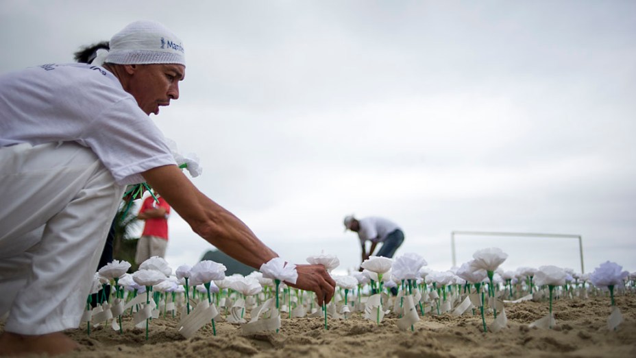 Ativistas plantam flores na areia para comemorar os 10 anos do projeto "Manifesto da Flores" (Manifesto da flor) na praia de Copacabana, Rio de Janeiro