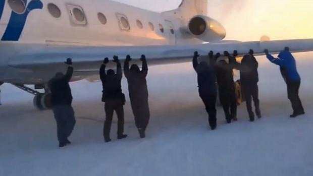 Passageiros dão 'empurrãozinho' para aeronave congelada sair do lugar na Sibéria