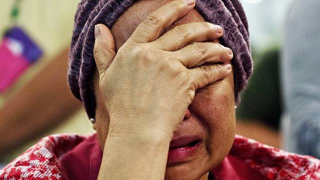 Mulher chora ao saber que a irmã é uma das vítimas do voo MH17 da Malaysia Airlines que caiu na Ucrânia, em Kuala Lumpur