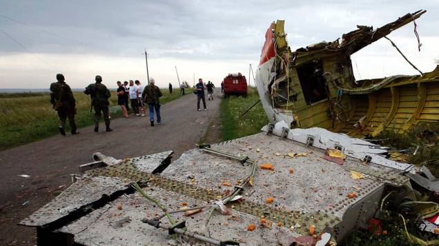 Pessoas são vistas próximo aos destroços do avião da Malaysia Airlines que caiu, em uma região controlada por rebeldes pró-Rússia no leste da Ucrânia