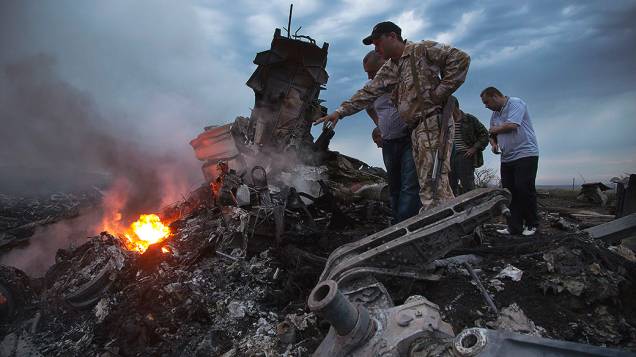 Pessoas observam o local onde o avião da Malaysia Airlines caiu na região de Donetsk, na Ucrânia oriental