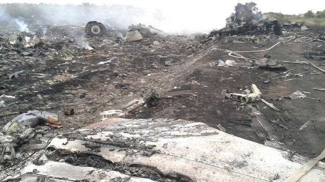 Oficiais do Ministério de Emergências trabalham no local onde o Boing 777 da Malaysia Airlines caiu na região de Donetsk, na Ucrânia oriental. Segundo as autoridades, o avião foi abatido sobre o território por militantes pró-Rússia, matando as 298<br> pessoas que estavam a bordo